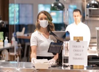 woman wearing mask accepting cashless payment